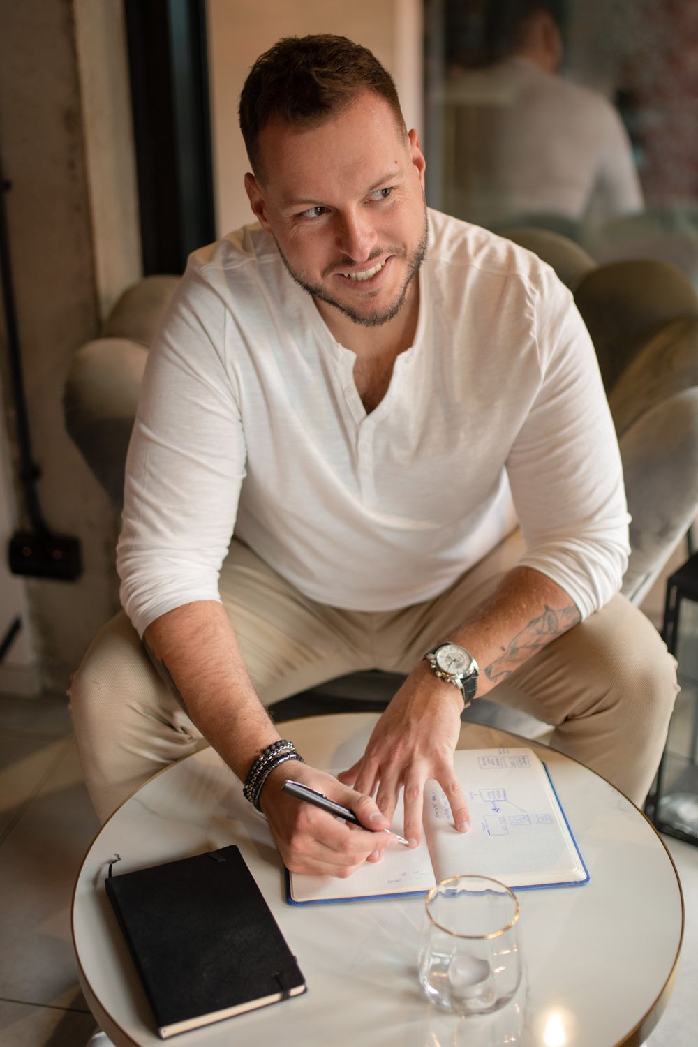 Kamil Lizurej z notesem, uśmiechnięty, podczas pracy