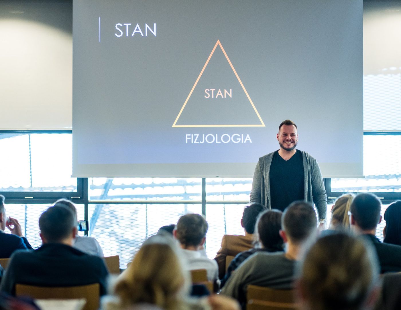 Kamil Lizurej przy slajdzie o stanie i fizjologii podczas szkolenia